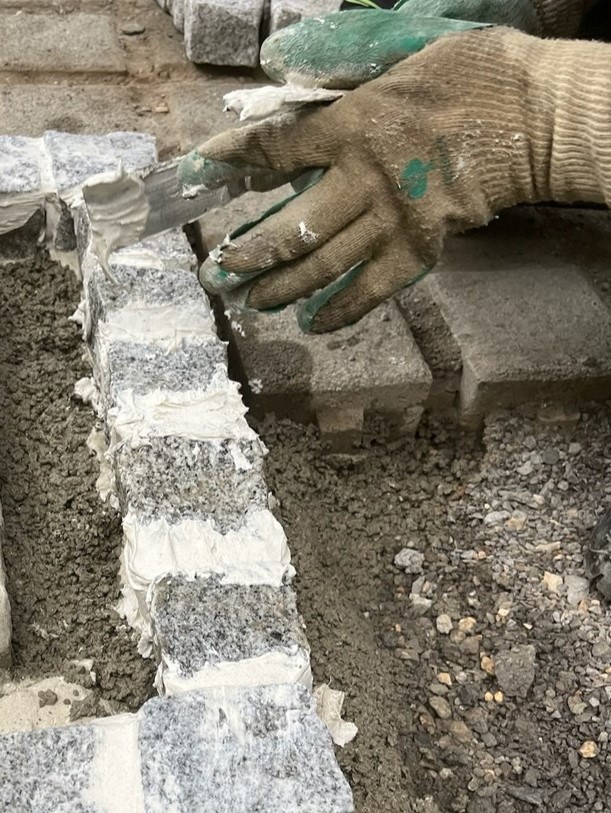 Handwerkliche Arbeit an einer Natursteineinfassung